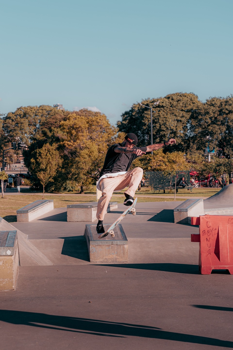 Black-and-white close-up of a heavily worn inline skate performing a rail grind, with distressed jeans and scuffed skate boots emphasizing street skating action and durability.